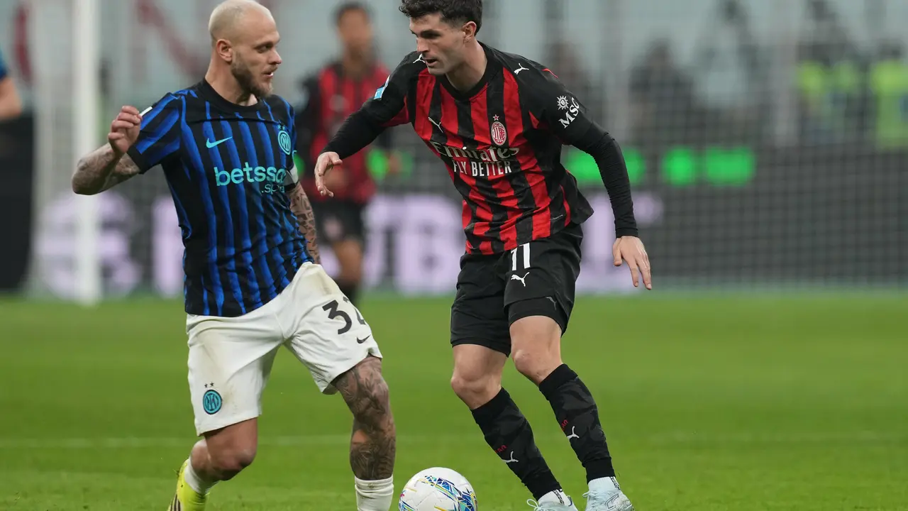 Pemain Inter Milan Federico Dimarco (kiri) berebut bola dengan pemain AC Milan Christian Pulisic