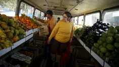 Seorang wanita mencari buah-buahan saat berbelanja di dalam pasar bus 'Sacolao' di Santa Teresa, Rio de Janeiro, Brasil, Selasa (7/7/2015). Pasar bus ini menjual sayur dan buah-buahan dengan harga yang terjangkau. (REUTERS/Pilar Olivares)