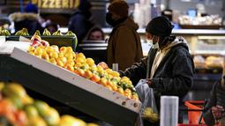 Seorang pembeli memilih buah di Reading Terminal Market di Philadelphia, Rabu (16/2/2022). Pejabat kota Philadelphia mencabut mandat vaksin untuk makan di dalam ruangan dan tempat lain yang menyajikan makanan dan minuman, tetapi mandat masker dalam ruangan tetap berlaku. (AP Photo/Matt Rourke)