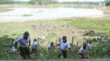 Personel TNI AL memotong rumput di sungai Citarum di Desa Warung Pulus, Bandung Barat, Jawa Barat, Minggu (17/12). Memperingati HUT TNI AL ke 72, melaksanakan operasi bakti TNI AL dengan menggelar acara "Bebersih Citarum". (Liputan6.com/Herman Zakharia)