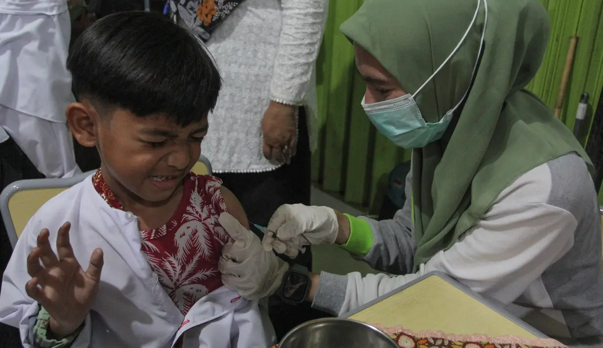 Petugas kesehatan Puskesmas Batu Sari menyuntikan vaksin imunisasi Campak-Rubella (MR) ke murid kelas 1 saat pelaksanaan bulan imunisasi anak sekolah (BIAS) 2025 di SDN Batu Jaya, Kota Tangerang, Banten, Jumat (15/8/2025). (merdeka.com/Arie Basuki)