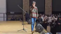 Momen Fiersa Besari manggung di Berlin, Jerman yang dibagikan pada Kamis (4/1/2024). Acara musik itu digelar di dalam gedung. Fiersa mengenakan sweater pemberian ibunya di tahun 2014. (Liputan6.com/IG Stories/fiersabesari)