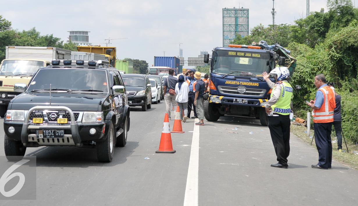 Petugas Kepolisian mengatur lalu lintas yang terdampak macet akibat truk menabrak tiang petunjuk arah di Tol Jakarta- Tangerang, Senin (5/9). Truk bernomor polisi B 935 IC menabrak tiang rambu lalu lintas di kilometer 6,5. (Liputan6.com/Yoppy Renato)