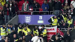 Bentrokan suporter Hungaria dengan polisi saat dimulainya laga Kualifikasi Piala Dunia 2022 melawan Inggris di Stadion Wembley, Rabu (13/10/2021) dini hari WIB. Bentrokan terjadi saat polisi berusaha menangkap penonton yang melakukan pelecehan rasial terhadap petugas stadion. (Nick Potts/PA via AP)