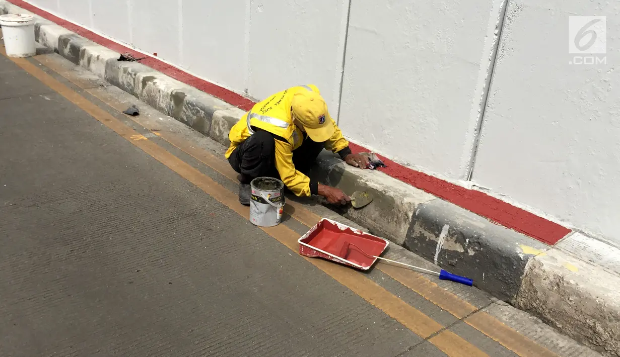 Petugas Pasukan Kuning mengecat dinding Underpass Kebayoran Baru, Jakarta Selatan, Kamis (1/2). Pengecatan dilakukan agar dinding underpass tidak kusam serta menghindari kesan kumuh. (Liputan6.com/Immanuel Antonius)