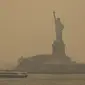 Patung Liberty yang diselimuti langit berkabut difoto dari Staten Island Ferry, New York, Amerika Serikat, Rabu (7/6/2023). New York resmi menjadi kota dengan tingkat udara paling tercemar di dunia, melampaui Kota New Delhi di India. (AP Photo/Yuki Iwamura)
