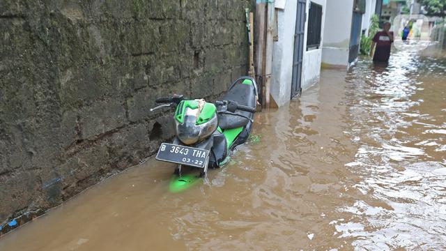 <span>Sebuah motor terendam saat banjir melanda kawasan Cipinang Melayu, Jakarta Timur, Jumat (19/2/2021). Banjir di kawasan tersebut akibat curah hujan yang tinggi dan meluapnya air dari Kali Sunter. (Liputan6.com/Herman Zakharia)</span>