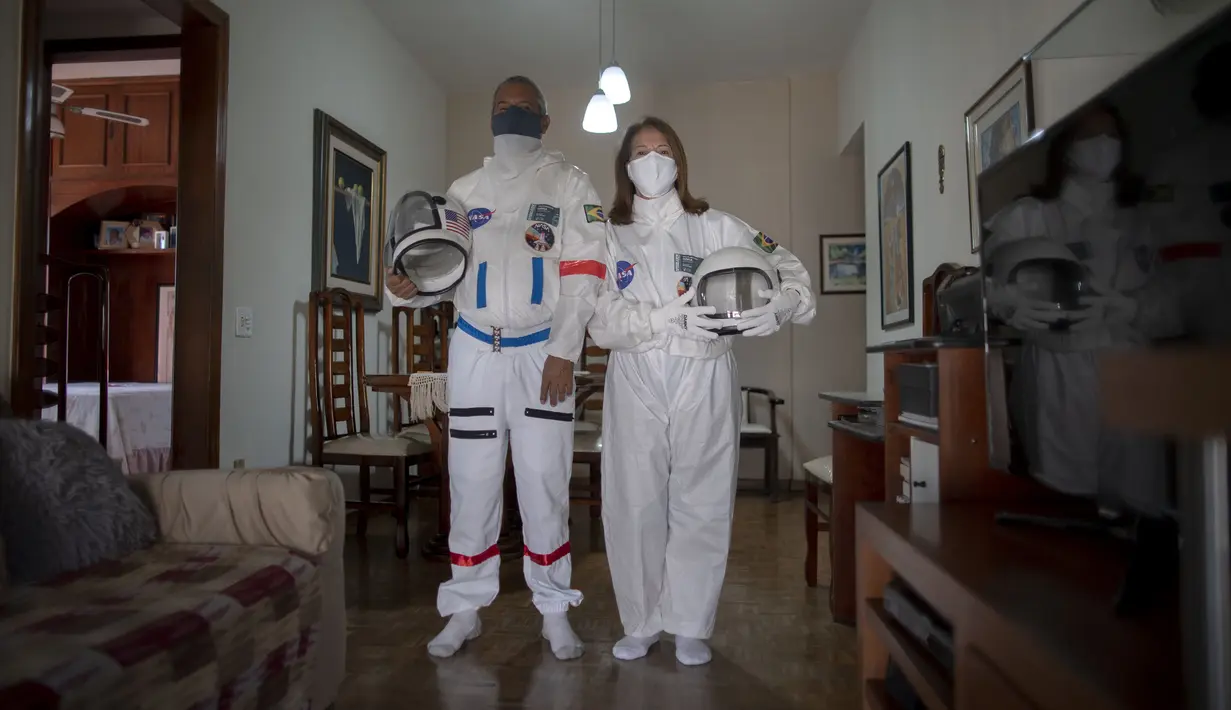 Akuntan Brasil Tercio Galdino (66) dan istrinya Alicea Galdino berpose dengan mengenakan pakaian pelindung mirip astronaut saat akan pergi ke Pantai Copacabana di Rio de Janeiro, Brasil, 12 Juli 2020. (Mauro Pimentel/AFP)