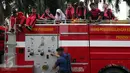 Sejumlah anak peserta Madrasah Siaga Bencana menaiki mobil pemadam kebakaran di hari bebas kendaraan bermotor di kawasan Thamrin, Jakarta, Minggu (22/1). (Liputan6.com/Johan Tallo)