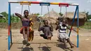Anak-anak pengungsi Sudan Selatan bermain ayunan saat istirahat makan siang di halaman sekolah pembibitan Ombechi di Bidi Bidi, Uganda, (5/6). Puluhan ribu orang telah terbunuh akibat perang saudara tersebut. (AP Photo/Ben Curtis)