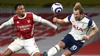 Penyerang Tottenham Hotspur, Harry Kane (kanan) menyundul bola di depan bek Arsenal, Gabriel dalam derby London Utara Liga Inggris di Emirates Stadium, Minggu (14/3/2021). Sempat tertinggal lebih dulu, Arsenal menang 2-1 di kandang sendiri melawan Tottenham Hotspur. (Dan Mullan/Pool via AP)