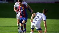 Penyerang Barcelona, Lionel Messi, melepaskan tembakan saat dikawal ketat oleh bek Osasuna, Facundo Roncaglia, pada laga pekan ke-11 La Liga 2020-2021 di Camp Nou, Minggu (29/11/2020) malam WIB. (AFP/Lluis Gene)