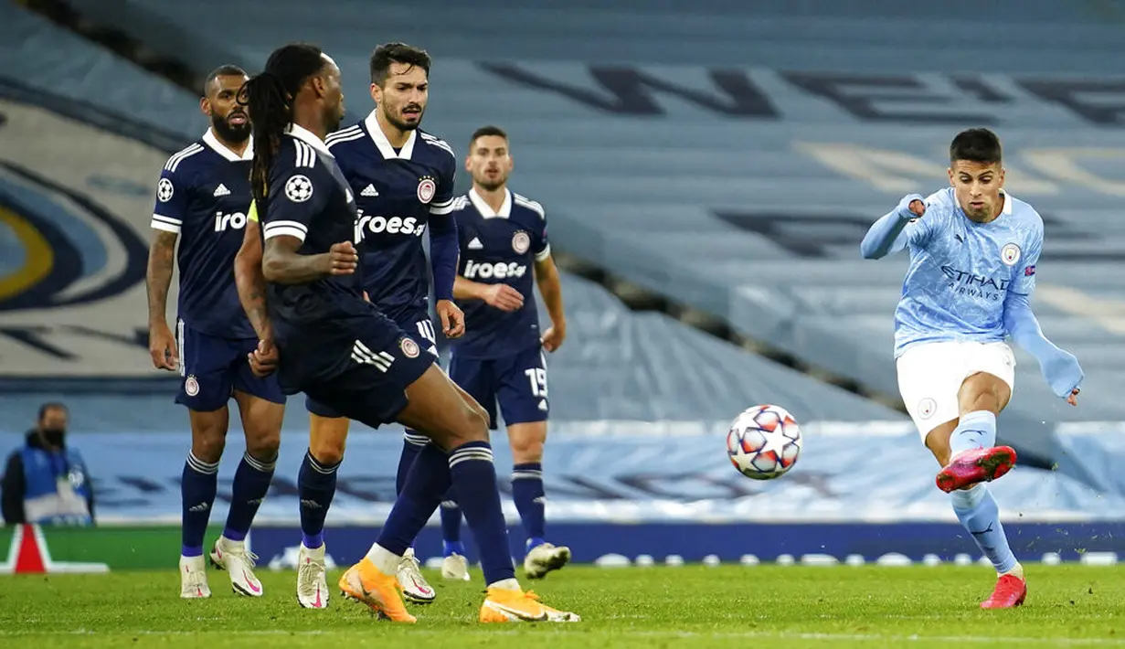 Pemain Manchester City Joao Cancelo (kanan) mencetak gol ke gawang Olympiacos pada pertandingan Grup C Liga Champions di Etihad Stadium di Manchester, Inggris, Selasa (3/11/2020). Manchester City mencukur Olympiacos dengan skor 3-0. (AP Photo/Dave Thompson)