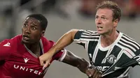 Pemain Wrexham, Aaron Hayden (kiri) berebut bola dengan pemain Manchester United, Jonny Evans pada laga uji coba pramusim di Snapdragon Stadium, San Diego, California, Rabu (25/07/2023) WIB. (AP Photo/Gregory Bull)