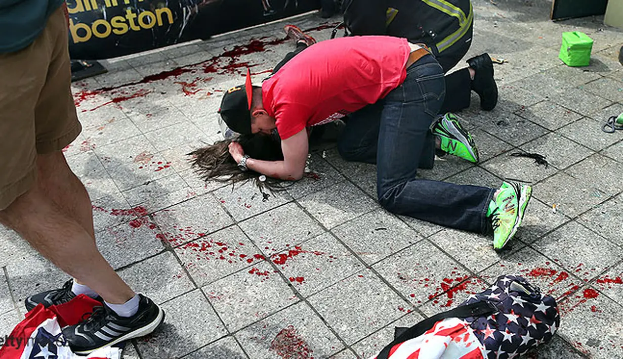Seorang pria memeluk korban BomBoston di area penonton Maraton.