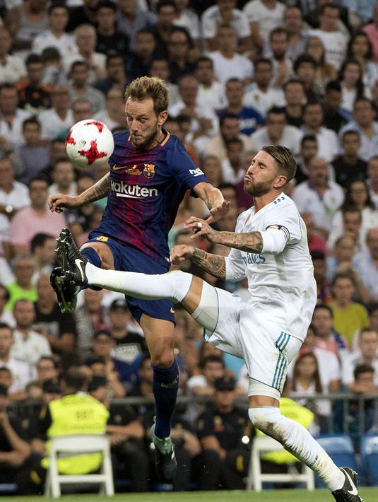 Aksi Barcelona, Ivan Rakitic (kiri) berebut bola dengan pemain Real Madrid, Sergio Ramos pada leg kedua Piala Super Spanyol di Santiago Bernabeu stadium (16/8/2017). Real menang 2-0. (AFP/Curto de La Torre)