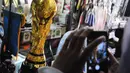 Seorang pengunjung tampak mengambil gambar replika Piala Dunia di sebuah toko kawasan Pasar Senen, Jakarta, Selasa (24/6/14). (Liputan6.com/Faizal Fanani) 