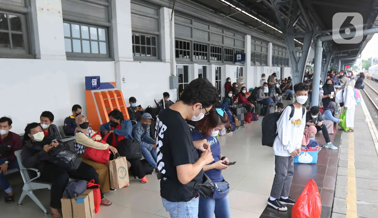Sejumlah calon penumpang menunggu untuk memasuki rangkaian kereta api Airlangga di Stasiun Pasar Senen, Jakarta, Minggu (10/4/2022). PT KAI Daop 1 telah membuka pelayanan kereta api jarak jauh sebanyak 22 perjalanan dengan kapasitas penumpang 100 persen. (Liputan6.com/Herman Zakharia)
