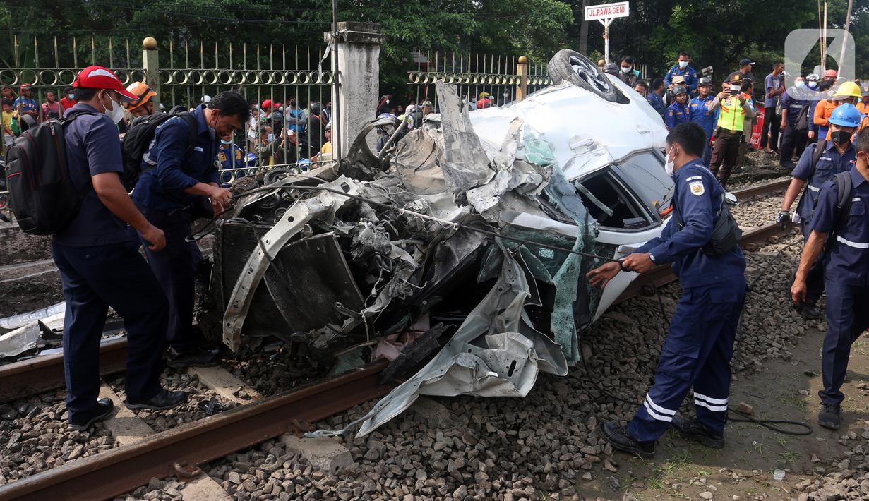 Petugas mengevakuasi mobil Honda Mobilio yang tertabrak KRL Commuterline KA 1077 (Bogor-Jakarta Kota) di kawasan Rawageni, Ratu Jaya, Cipayung, Depok, Jawa Barat, Rabu (20/4/2022). Kecelakaan yang terjadi di perlintasan sebidang itu menyebabkan terganggunya perjalanan KRL. (merdeka.com/Arie Basuki)