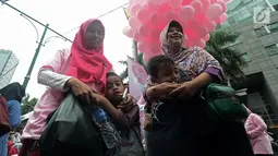 Anak-anak memeluk ibunya saat acara "Peluk Ibu Satu Indonesia"  selama Car Free Day di Bundaran HI, Jakarta, Minggu (23/12). Acara itu dalam rangka memperingati hari ibu dan mengajak masyarakat untuk selalu menghormati ibu. (Merdeka.com/Iqbal S. Nugroho)