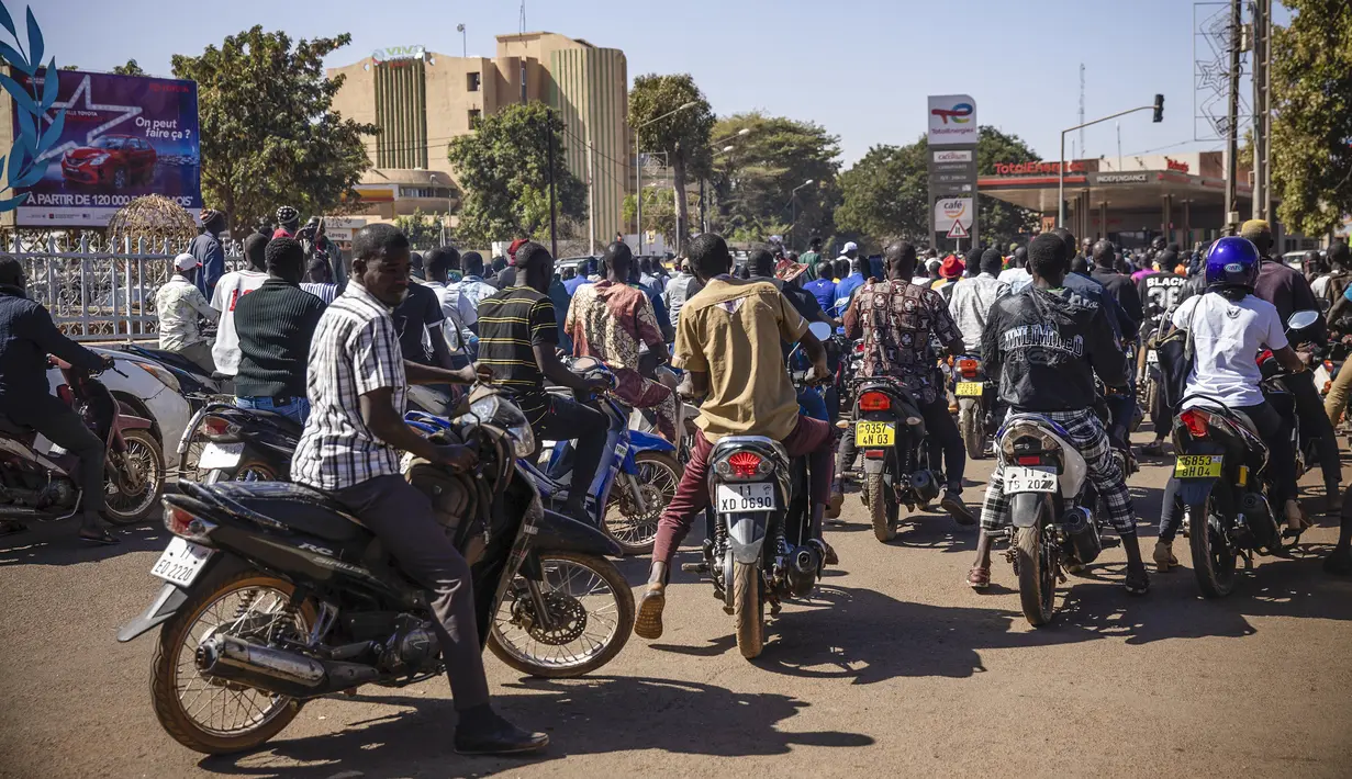 Orang-orang bersorak mendukung tentara kudeta di dekat stasiun televisi nasional di Ouagadougou, Senin (24/1/2022). Diketahui, situasi keamanan di Burkina Faso dalam beberapa bulan ini tengah panas akibat seringnya pembunuhan terhadap warga sipil dan tentara oleh militan. (AP/Sophie Garcia)