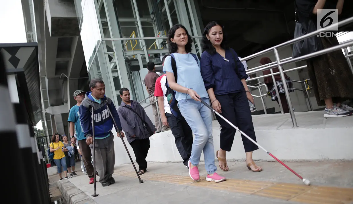 Seorang penyandang disabilitas menyusuri ubin pemandu menuju Stasiun LRT Veldrome, Jakarta, Sabtu (27/4). Kegiatan yang diikuti Jakarta Barrier Free Tourism (JBFT) tersebut untuk mengenalkan kereta Lintas Rel Terpadu (LRT)  lebih dekat kepada masyarakat. (Liputan6.com/Faizal Fanani)