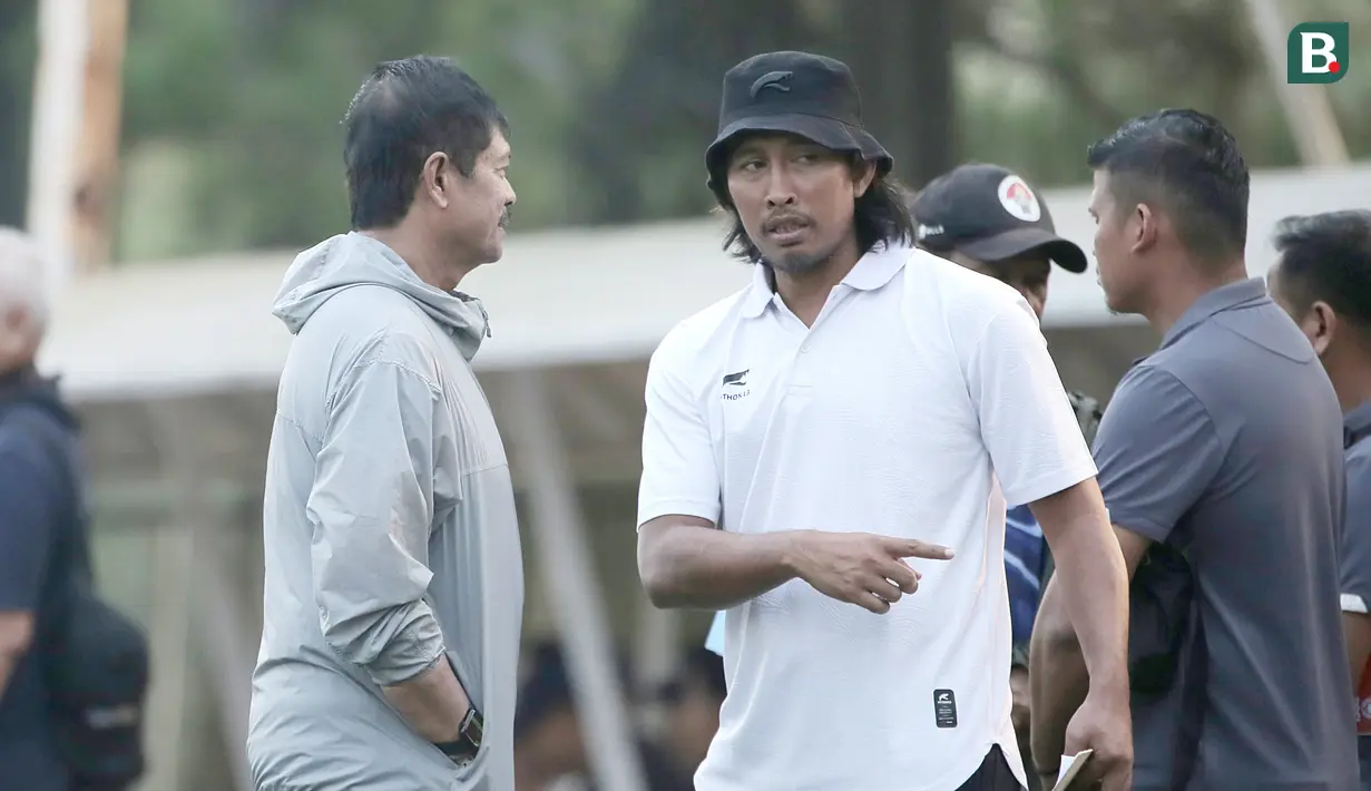 Pelatih Timnas Indonesia U-20, Indra Sjafri berbincang dengan Budi Sudarsono saat memantau langsung seleksi pemain Timnas Indonesia U-17 di Persija Training Ground, Nirwana Park, Depok, Sabtu (22/7/2023). (Bola.com/Ikhwan Yanuar)