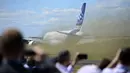 Pengunjung pameran menyaksikan detik-detik lepas landasnya Airbus A380-800 yang melakukan demo terbang di Farnborough Airshow di Hampshire, Inggris, (14/7/2014). (AFP PHOTO/Carl Court)  