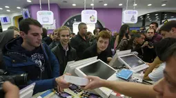 Seorang pria memegang iPhone 6 di sebuah toko ponsel di Moskow, (26/9/2014). iPhone 6 dan iPhone 6 plus mulai dipasarkan di sejumlah kota besar lain di Rusia. (REUTERS/Maxim Shemetov)