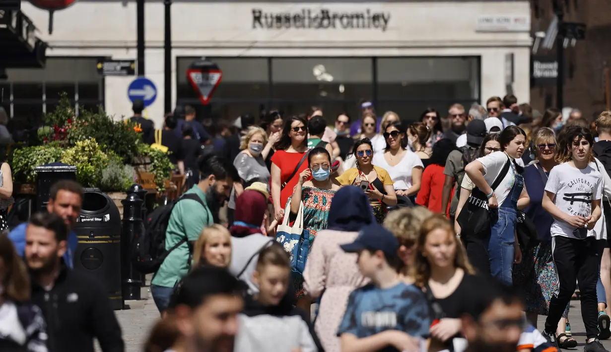 Orang-orang berjalan melalui Covent Garden di pusat kota London pada Kamis (3/6/2021). Pemerintah Inggris belum bisa memastikan akan sepenuhnya mencabut lockdown yang berakhir pada 21 Juni nanti meski kasus Covid-19 mengalami tren penurunan. (Tolga Akmen/AFP)