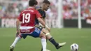 Penyerang Granada #19 Facundo Pellistri (Kiri) bersaing dengan gelandang Real Madrid  #19 Daniel Ceballos pada matchday ke-35 L La Liga 2023/2024 di Stadion Nuevo Los Carmenes, Sabtu (11/5/2024). (JORGE GUERRERO / AFP)