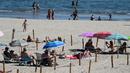 Orang-orang menikmati sore dengan area terpisah untuk mematuhi jaga jarak di pantai "Plage du Couchant" di La Grande-Motte, Prancis Selatan, Selasa (26/5/2020). Area pemisah itu berupa kotak-kotak yang dibatasi dengan tali yang masing-masing berjarak 2 meter antar satu sama lain. (Pascal GUYOT/AFP)