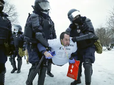 Polisi menahan seorang pria selama protes menuntut pembebasan pemimpin oposisi Alexei Navalny di St. Petersburg, Rusia, Sabtu (23/1/2021). Polisi Rusia bentrok dengan pengunjuk rasa di Moskow dan menangkap setidaknya 2.131 demonstran. (AP Photo/Dmitri Lovetsky)