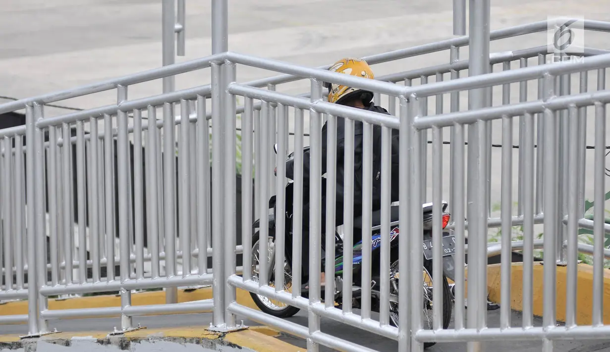 Pengendara sepeda motor melintasi JPO di Jalan Yos Sudarso, Jakarta, Senin (12/11). Aksi nekat yang dilakukan para pengendara sepeda motor demi mempersingkat rute jalan tersebut dapat membahayakan diri mereka sendiri. (Merdeka.com/Iqbal S. Nugroho)