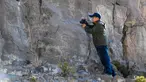 Seorang arkeolog memotret lukisan batu di klaster seni cadas Gunung Zhuozi di Daerah Otonom Mongolia Dalam, China pada 17 Oktober 2020. Gunung Zhuozi adalah tempat dengan banyak lukisan batu yang berguna untuk penelitian tentang asal muasal nomad kuno di China. (Xinhua/Peng Yuan)
