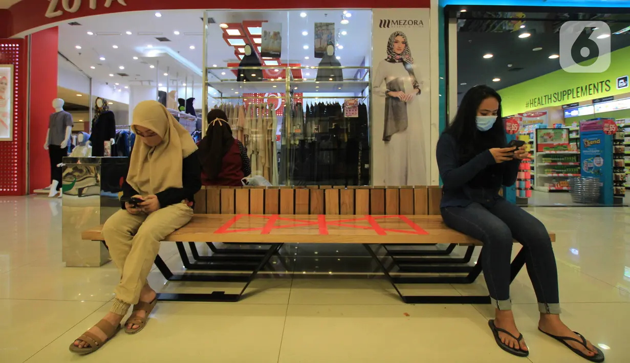 Pengunjung bermain ponsel di Mal Tangerang City di Kota Tangerang, Banten, Selasa (23/6/2020). Sejumlah mal di Tangerang telah dibuka kembali dengan menerapkan protokol kesehatan dalam melayani masyarakat selama status Pembatasan Sosial Berskala Besar (PSBB). (Liputan6.com/Angga Yuniar)