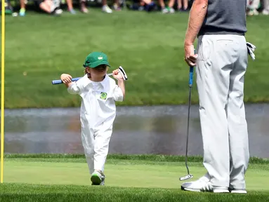 Austin, putri dari pegolf Brandt Snedeker berjalan saat mengikuti acara Masters Par 3 Tournament di Augusta National Golf Club, Georgia, (5/4). Anak-Anak ini menunjukkan keterampilannya bermain golf bersama orang tuanya. (AFP Photo/Jim Watson)