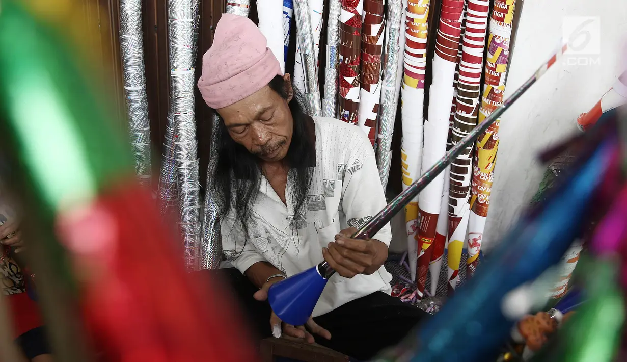 Pengrajin menyelesaikan pembuatan terompet di kawasan Glodok, Jakarta, Selasa (25/12). Menjelang tahun baru terompet konvensional tersebut dijual dengan harga dari Rp 5000 hingga Rp 10.000 tergantung ukuran dan jenisnya. (Liputan6.com/Herman Zakharia)