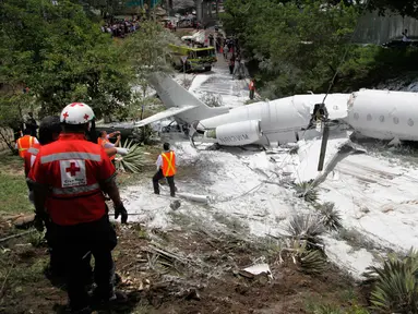 Sebuah pesawat jet pribadi Gulfstream G200 tertutup busa yang disemprotkan petugas pemadam kebakaran setelah tergelincir di Bandara Tegucigalpa, Honduras, Selasa (22/5). Sedikitnya 6 dilaporkan terluka dalam insiden tersebut. (AP/Fernando Antonio)