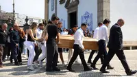 Orang tua Diogo Jota (kiri) mengikuti peti jenazah putranya&nbsp;yang dibawa keluar gereja setelah upacara pemakaman Diogo Jota dan adiknya, Andre Silva, di Gereja Induk Gondomar, di pinggiran Porto, pada 5 Juli 2025. Pemain depan Liverpool, Diogo Jota, dan saudaranya meninggal dalam kecelakaan mobil di Spanyol pada 3 Juli 2025, yang memicu kesedihan yang meluas tepat setelah bintang Portugal itu menikah. (FILIPE AMORIM/AFP)