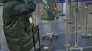 Seorang perempuan mengambil gambar Pohon Natal dari barang-barang sitaan di Bandara Vilnius, Lithuania pada 12 Desember 2019. Bandara Lithuania mengatakan pohon ini dikumpulkan dari barang-barang terlarang yang disita petugas selama proses penyaringan. (Photo by Petras Malukas / AFP)
