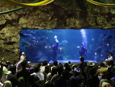 Pengunjung menyaksikan penyelam saat bermain bola di dalam aquarium Sea World, Jakarta, Sabtu (16/6). Atraksi tersebut digelar dalam rangka menyemarakkan ajang Piala Dunia 2018 yang berlangsung di Rusia. (Liputan6.com/Immanuel Antonius)