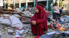 Seorang wanita duduk di antara reruntuhan di sekolah Fahmi Al-Jarjawi, kota Gaza, pada 26 Mei 2025. (Omar AL-QATTAA/AFP)