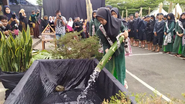 Warga menuangkan air dari Tuk Sikopyah dalam Festival Gunung Slamet 2019. (Foto: Liputan6.com/Humas PBG/Muhamad Ridlo)