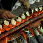 Pekerja mengambil lemang bambu di sentra pembuatan lemang kawasan Kramat Raya, Senen, Jakarta, Jumat (17/6). Pembuatan lemang pada Ramadan meningkat lebih dari 300 persen dibanding hari biasa hingga mencapai 500 buah per-hari (Liputan6.com/Gempur M Surya)