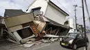 Sebuah kendaraan melintas di dekat rumah-rumah yang runtuh setelah gempa bumi di Yatsushiro, Prefektur Kumamoto, Rabu, 29 Juli 2026. (Juntaro Yokoyama/Kyodo News via AP)