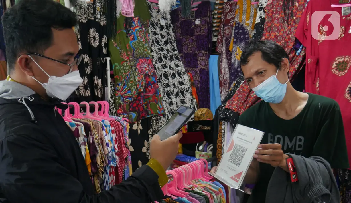 Pegawai BSI Cabang Mayestik menggunakan scan QRIS di salah satu kios saat Grebek Pasar BSI di Pasar Mayestik, Jakarta (16/12/2021). Grebek pasar BSI akan dilakukan secara nasional yang menyasar pasar tradisional dan dikelola oleh Pemda setempat. (Liputan6.com/HO/Rizky)
