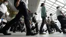Komuter yang mengenakan masker berjalan di lorong selama jam sibuk di Stasiun Shinagawa, Tokyo, Senin (12/7/2021). Otoritas Jepang menempatkan Tokyo di bawah keadaan darurat Covid-19 keempat sebagai upaya menahan lonjakan kasus infeksi virus Corona dari Senin hingga 22 Agustus. (AP /Eugene Hoshiko)
