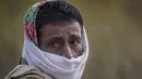 Atul Teron, 52, seorang warga suku yang membungkus wajahnya dengan selendang di desa Panbari, sekitar 50 kilometer (31 mil) timur di Gauhati, India, 13 Januari 2022. Teron mengatakan dia tidak bisa membeli masker di desanya dan dia lebih suka mengikat syal di wajahnya. (AP Photo/Anupam Nath)