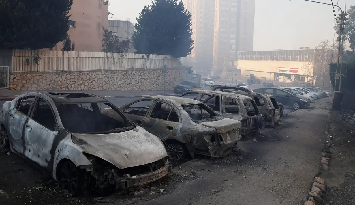 Sejumlah mobil terbakar saat kebakaran melanda kawasan Haifa, Israel, Kamis (24/11). Api awalnya membakar semak-semak kemudian meluas hingga ke pemukiman. (REUTERS / Baz Ratner)